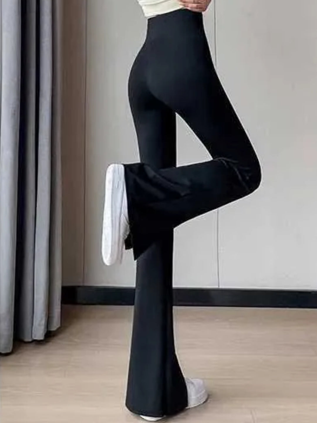 high-waist black yoga pants with a front slit, paired with white sneakers