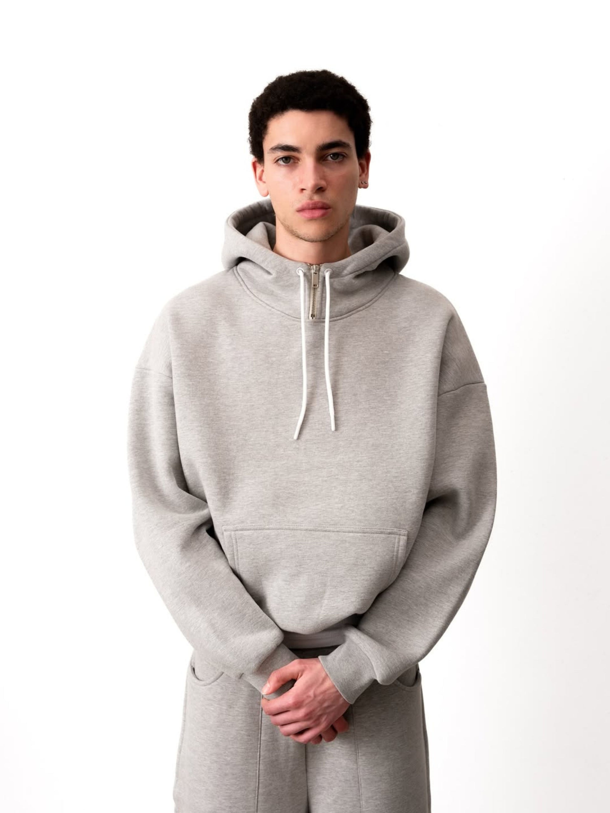 Person wearing a gray hoodie on a white background