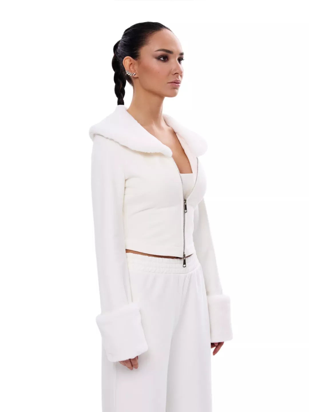 Woman wearing a white outfit with a high collar on a white background
