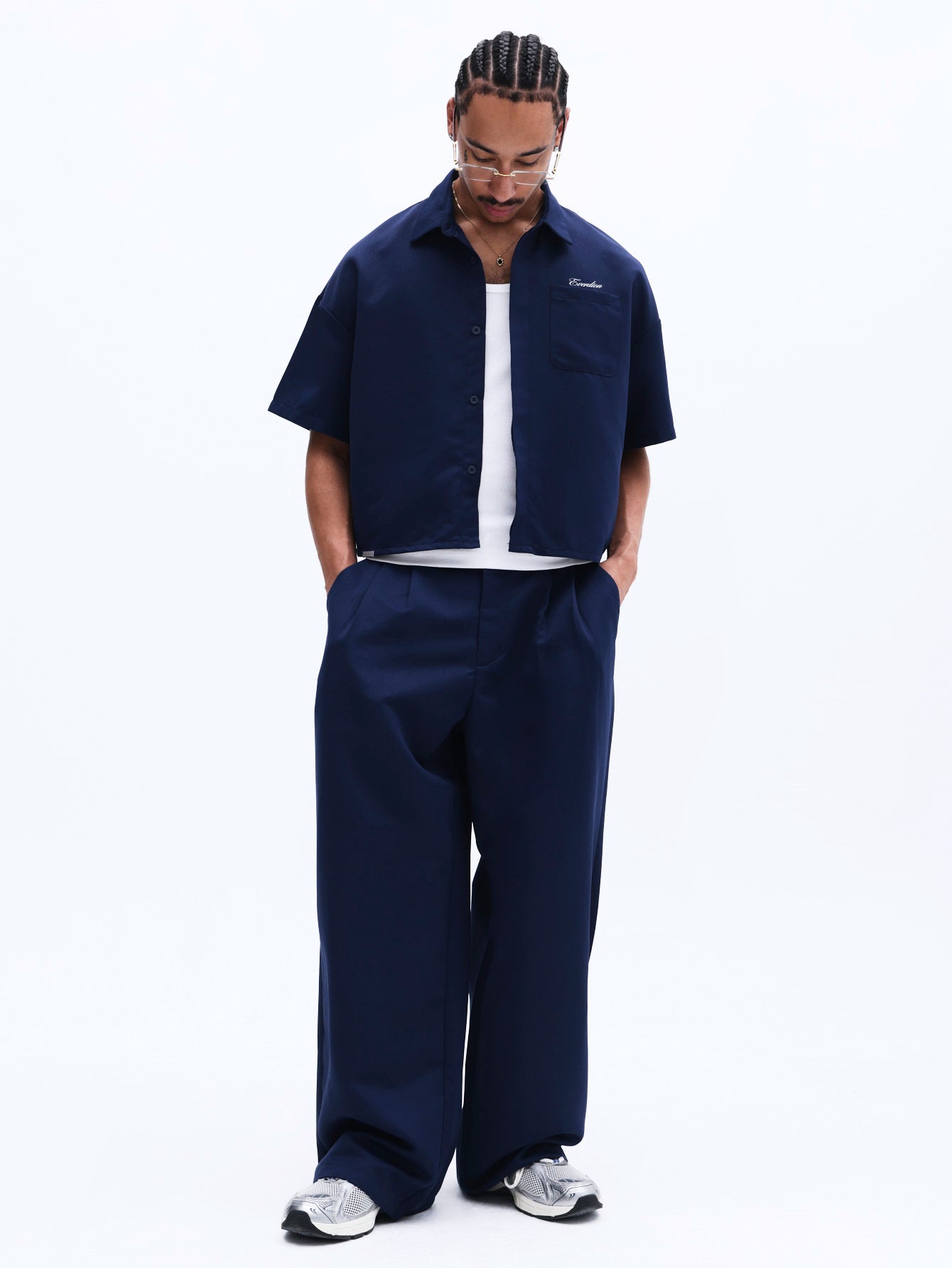 Person wearing a navy blue shirt and pants on a white background
