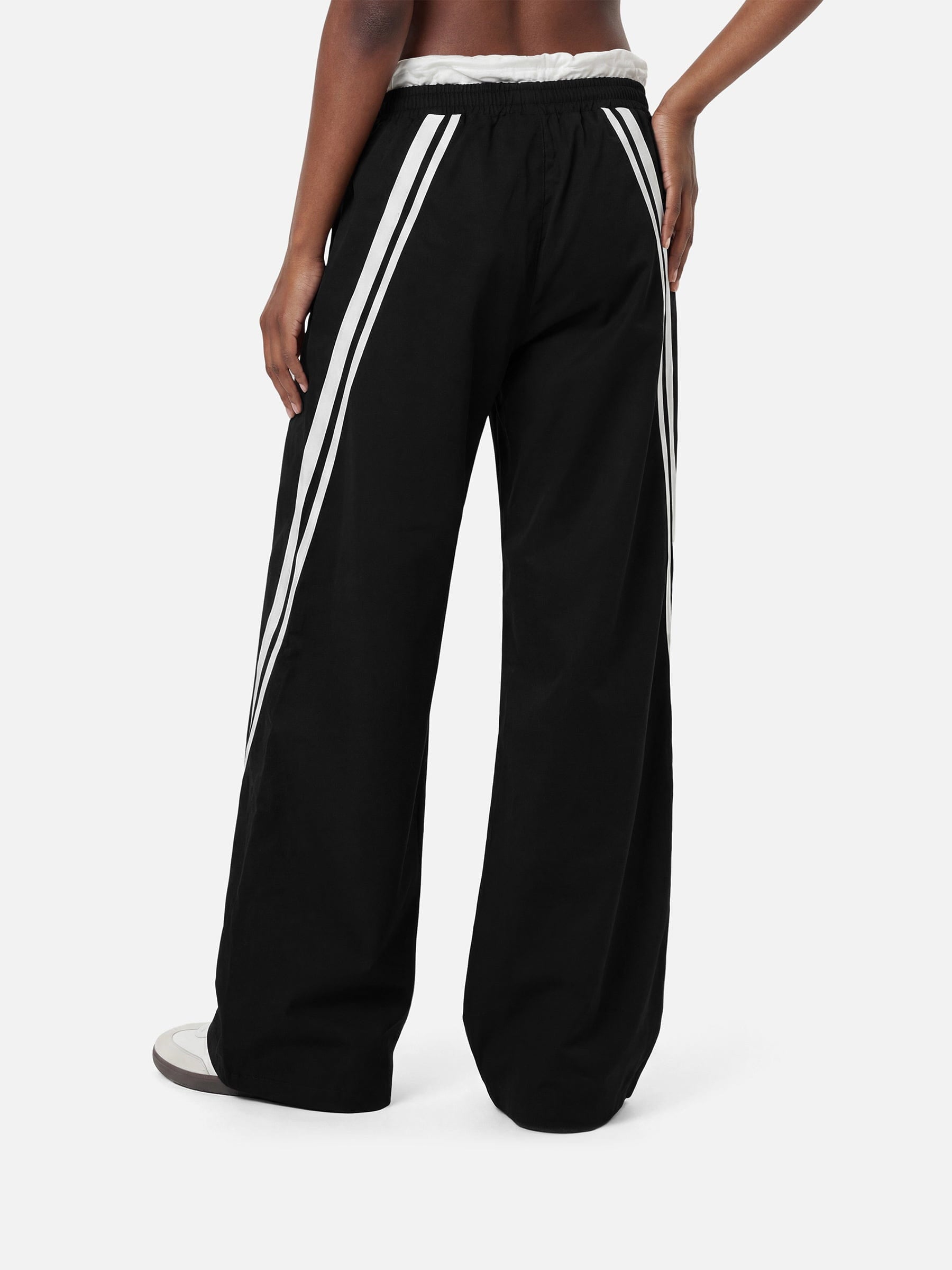 Black wide-leg pants with white stripes on a white background