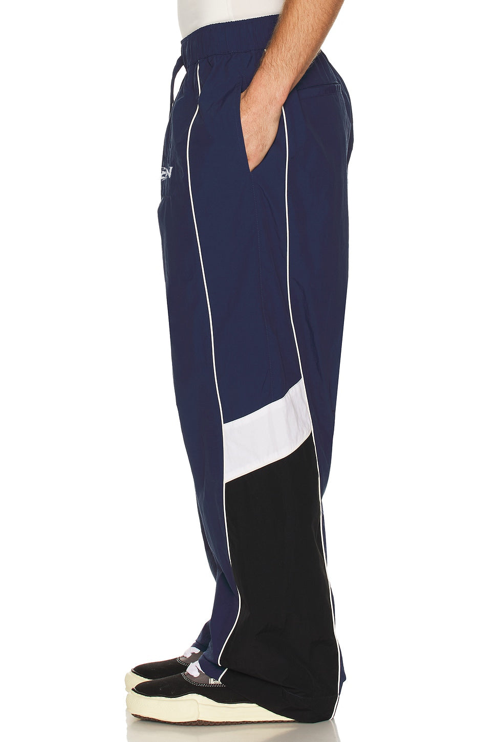 Navy and white track pants with a brand logo on a white background