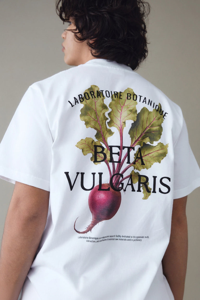 Person wearing a white t-shirt with a beet graphic and text on the back.