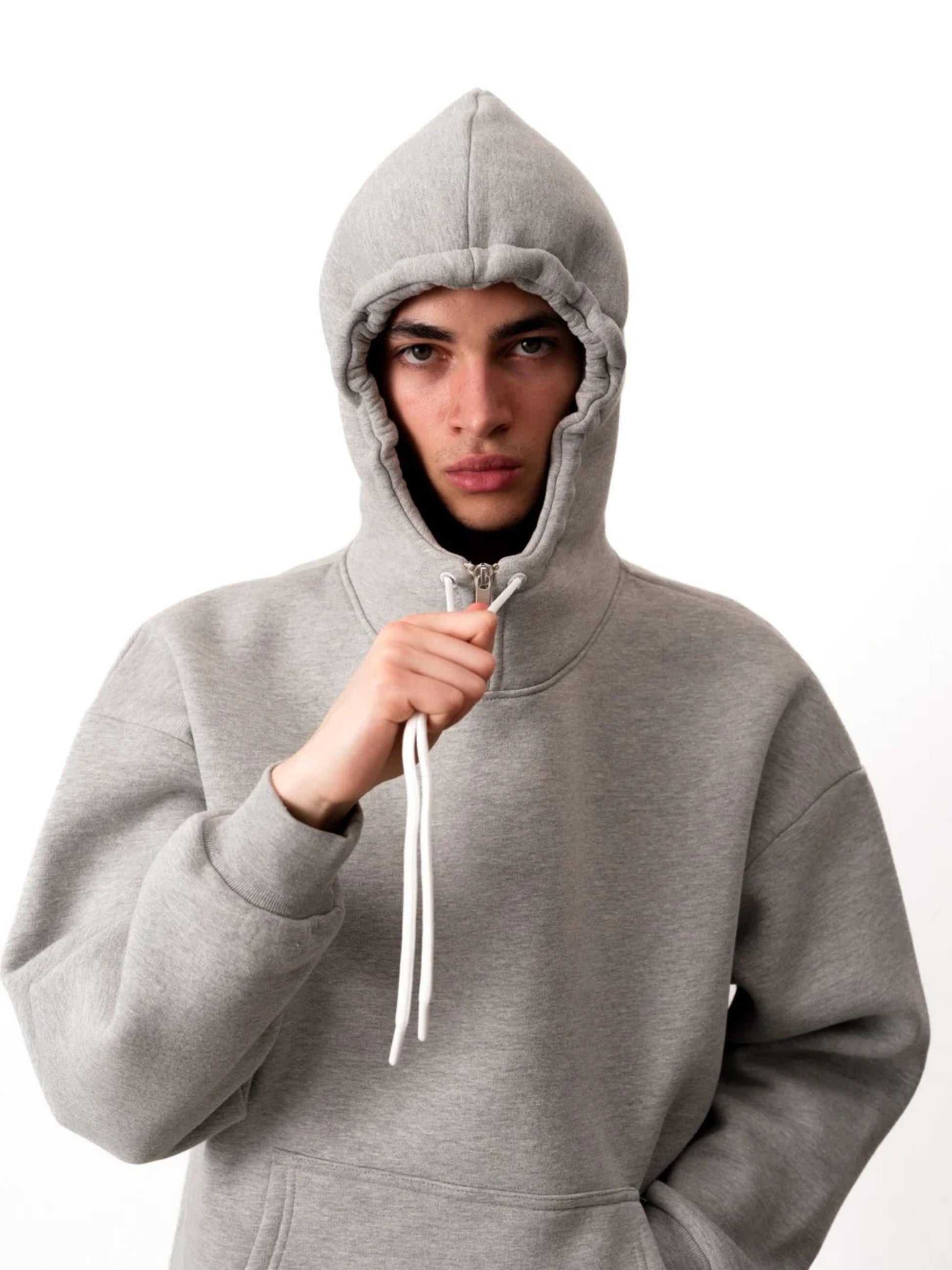Person wearing a gray hoodie on a white background