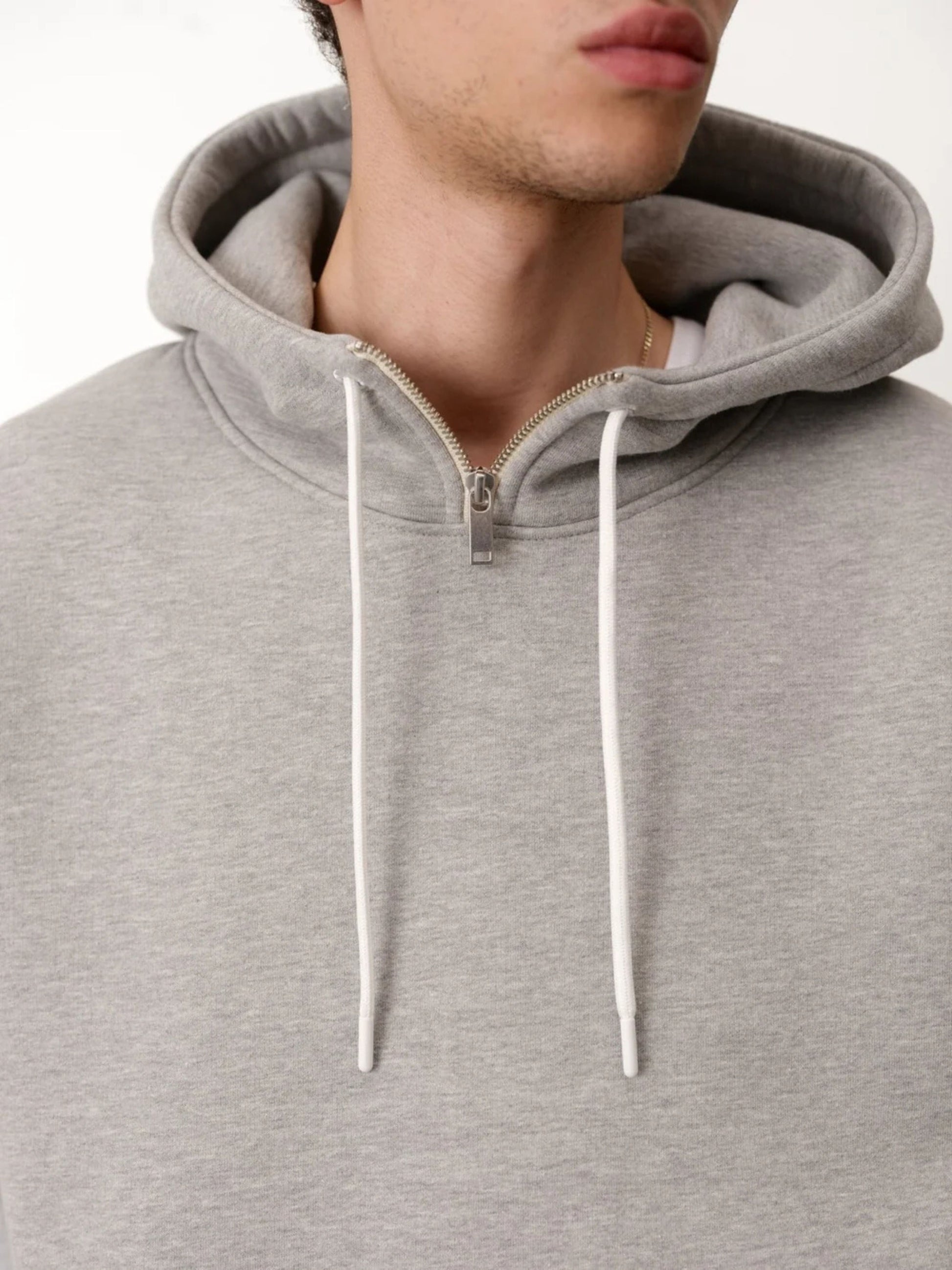 Grey hoodie with a zipper on a plain background