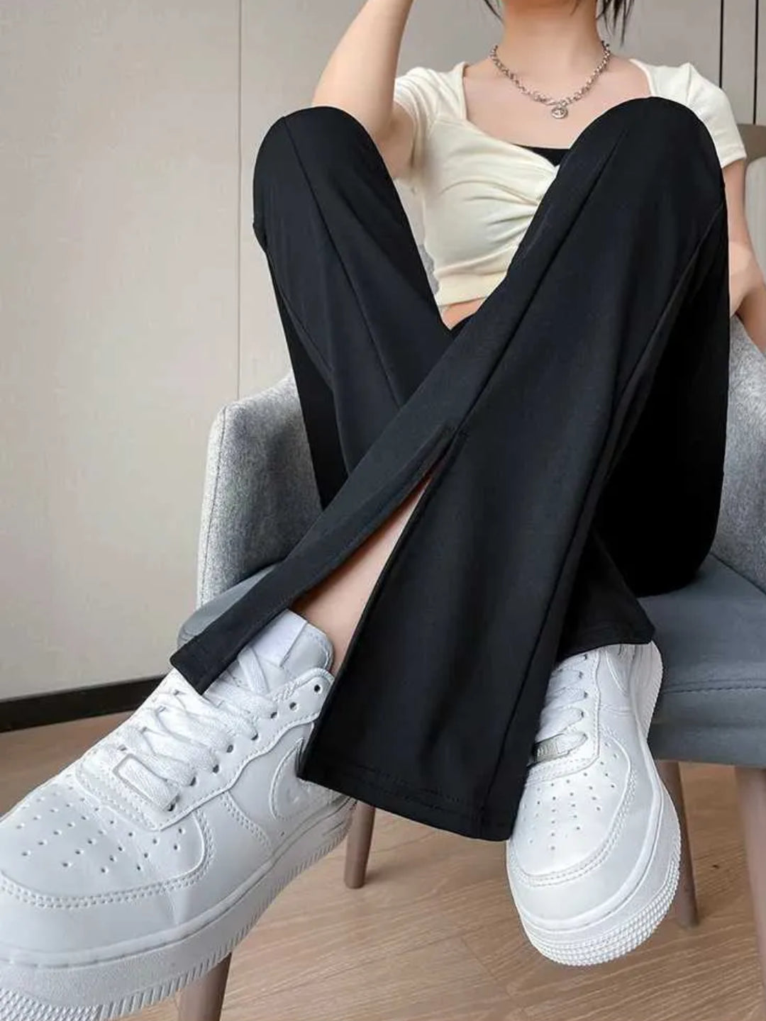 high-waist black yoga pants with a front slit, paired with white sneakers