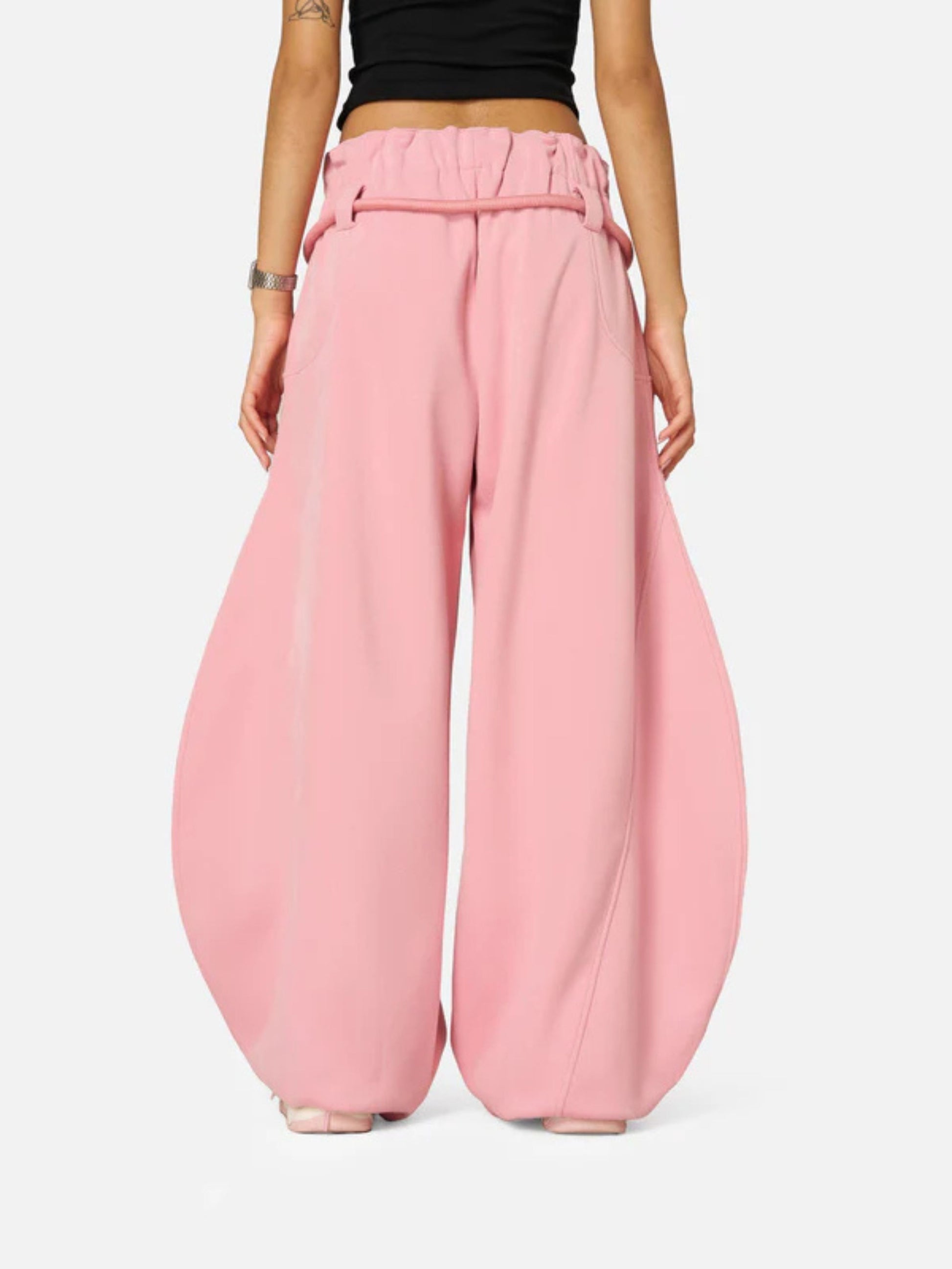 Person wearing pink wide-leg pants on a white background