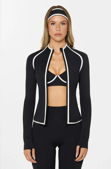 Woman wearing a black athletic jacket with white trim on a white background