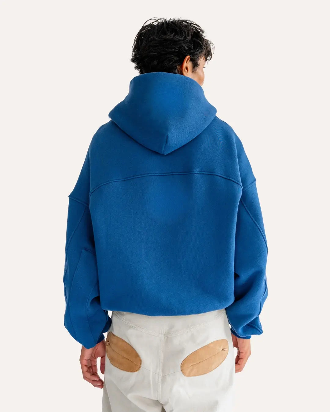 Person wearing a blue hoodie from behind on a white background