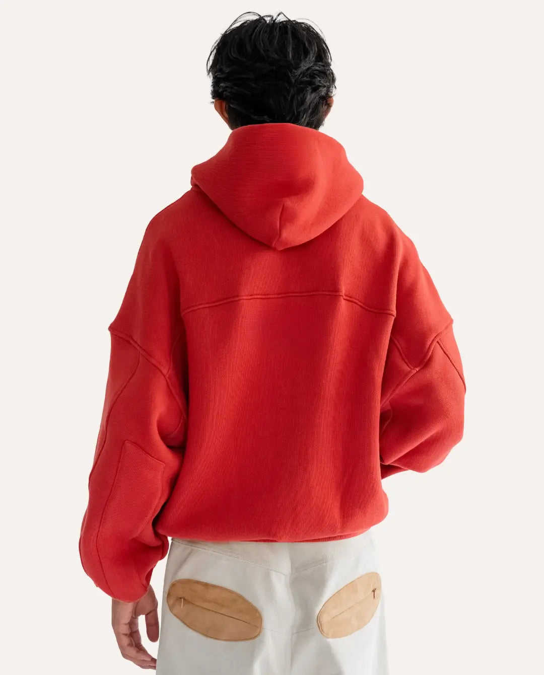 Person wearing a red hoodie from behind on a white background