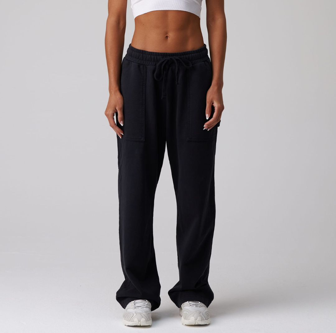 A pair of black jersey carpenter sweatpants with an adjustable toggle hem at the ankle, featuring multiple pockets.