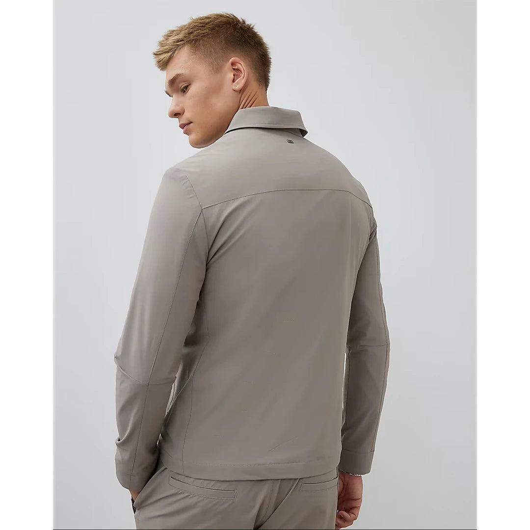 Man wearing a beige jacket and pants on a white background