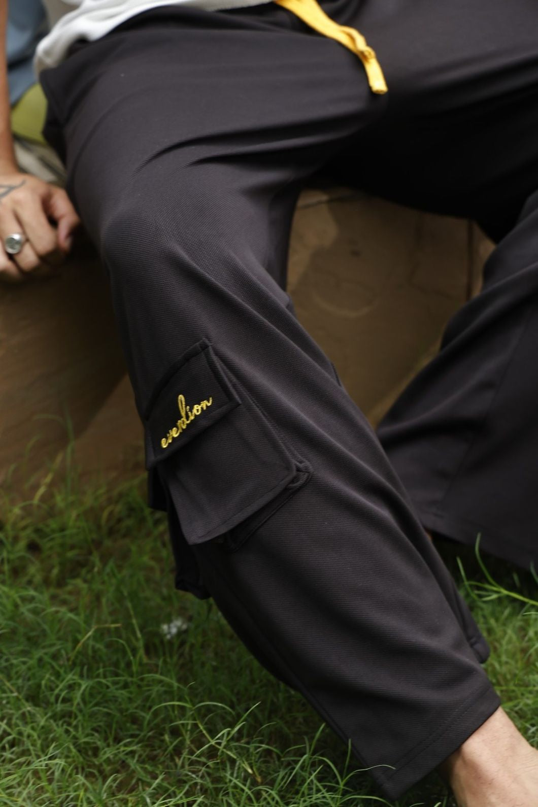 Black pants with yellow branding on a grassy surface