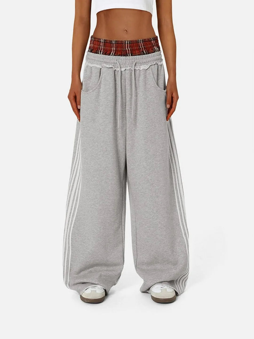 Grey sweatpants with red plaid waistband on a white background