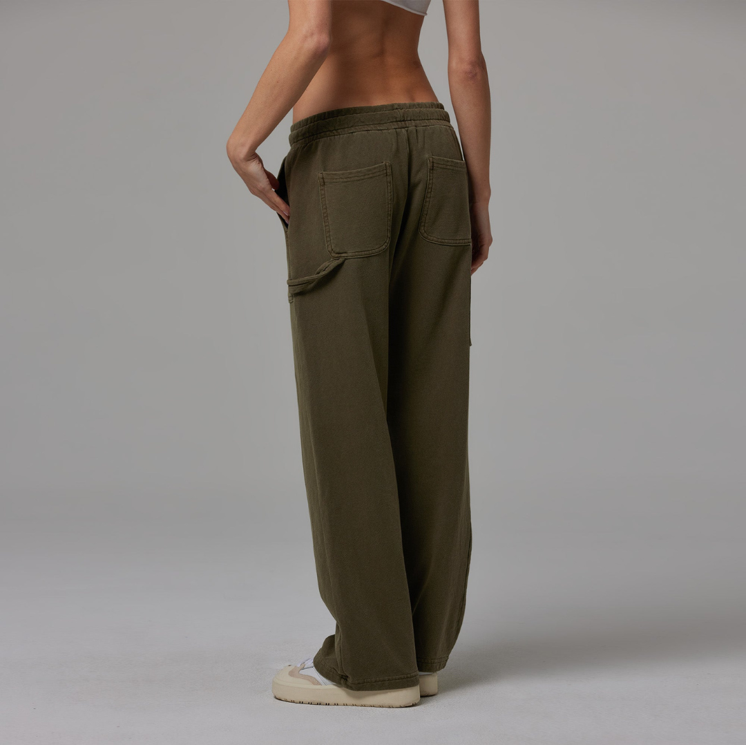Olive jersey carpenter sweatpants with an adjustable toggle hem at the ankle, featuring multiple pockets.