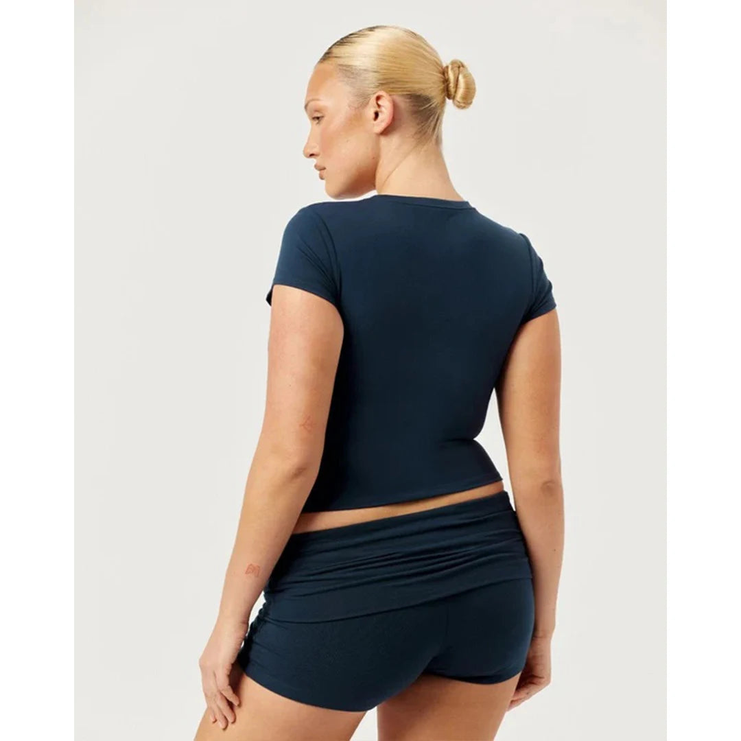 Woman wearing a navy blue athletic outfit on a white background