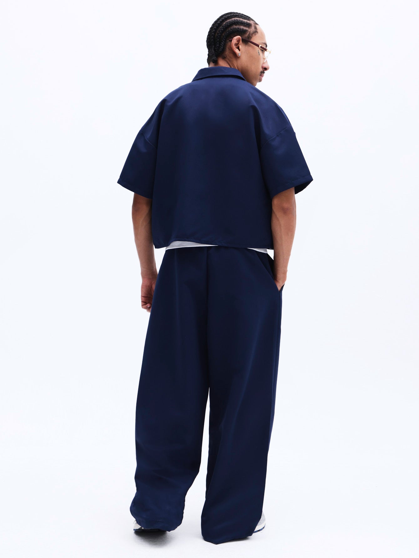 Person wearing a navy blue outfit on a white background