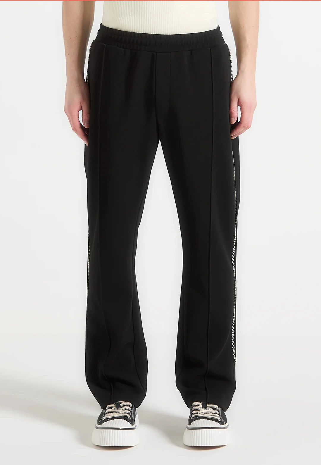 Person wearing black pants with a white background