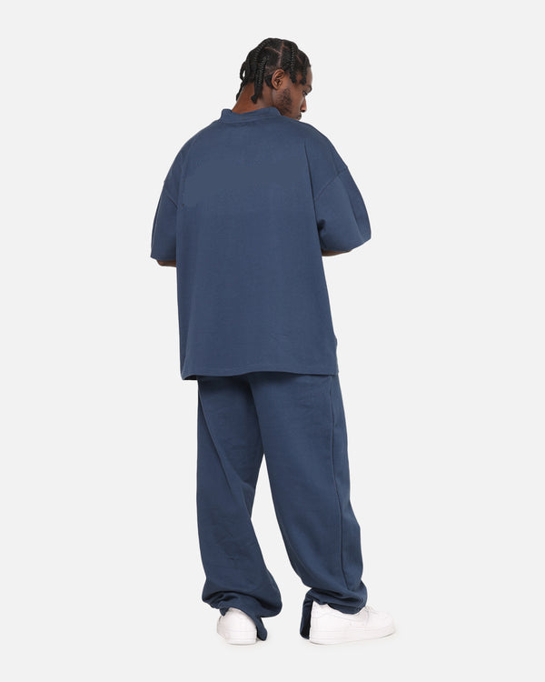 Person wearing a blue outfit with white shoes on a white background