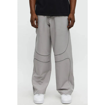 Person wearing gray pants with a plain background