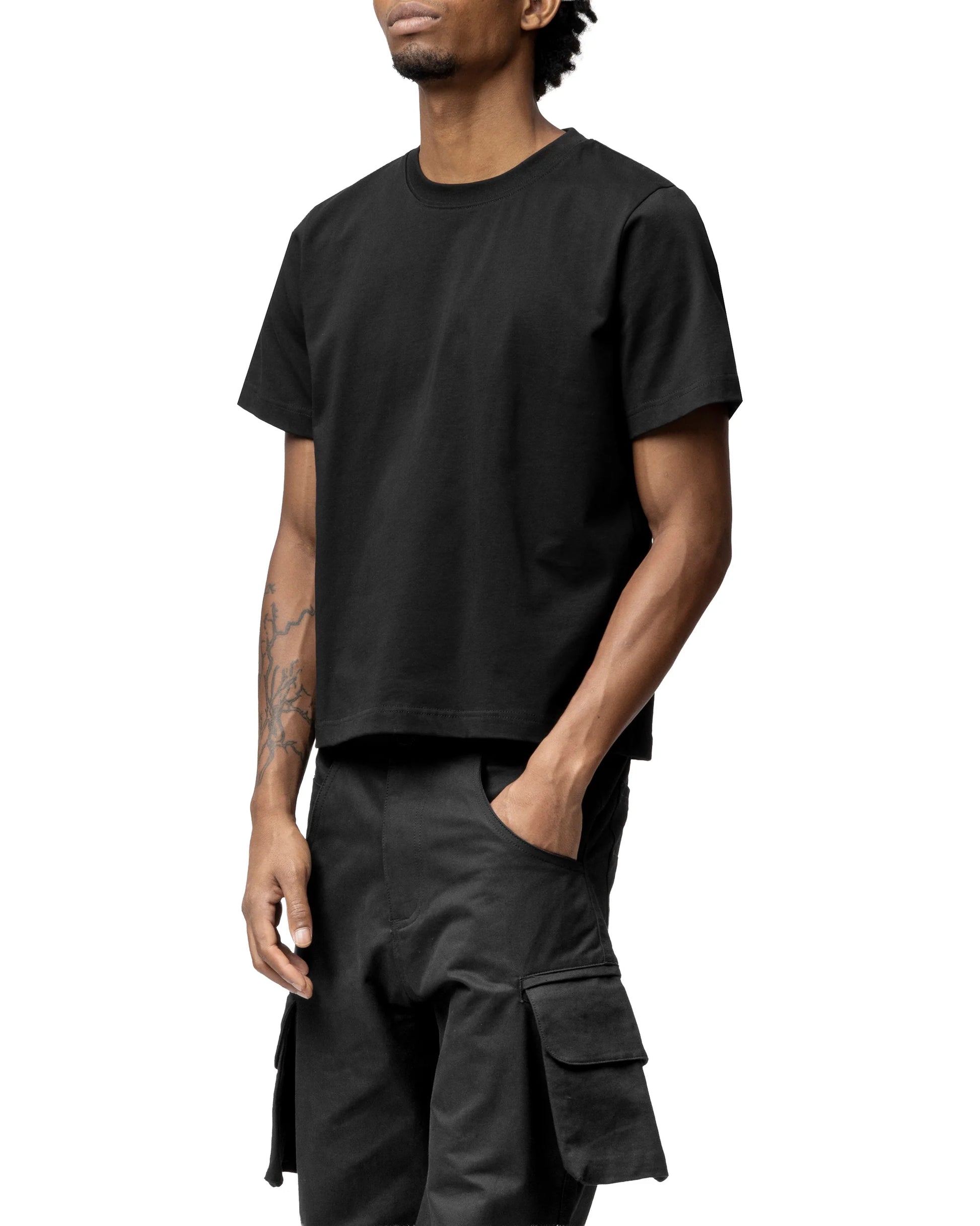Person wearing a black t-shirt and dark pants on a white background
