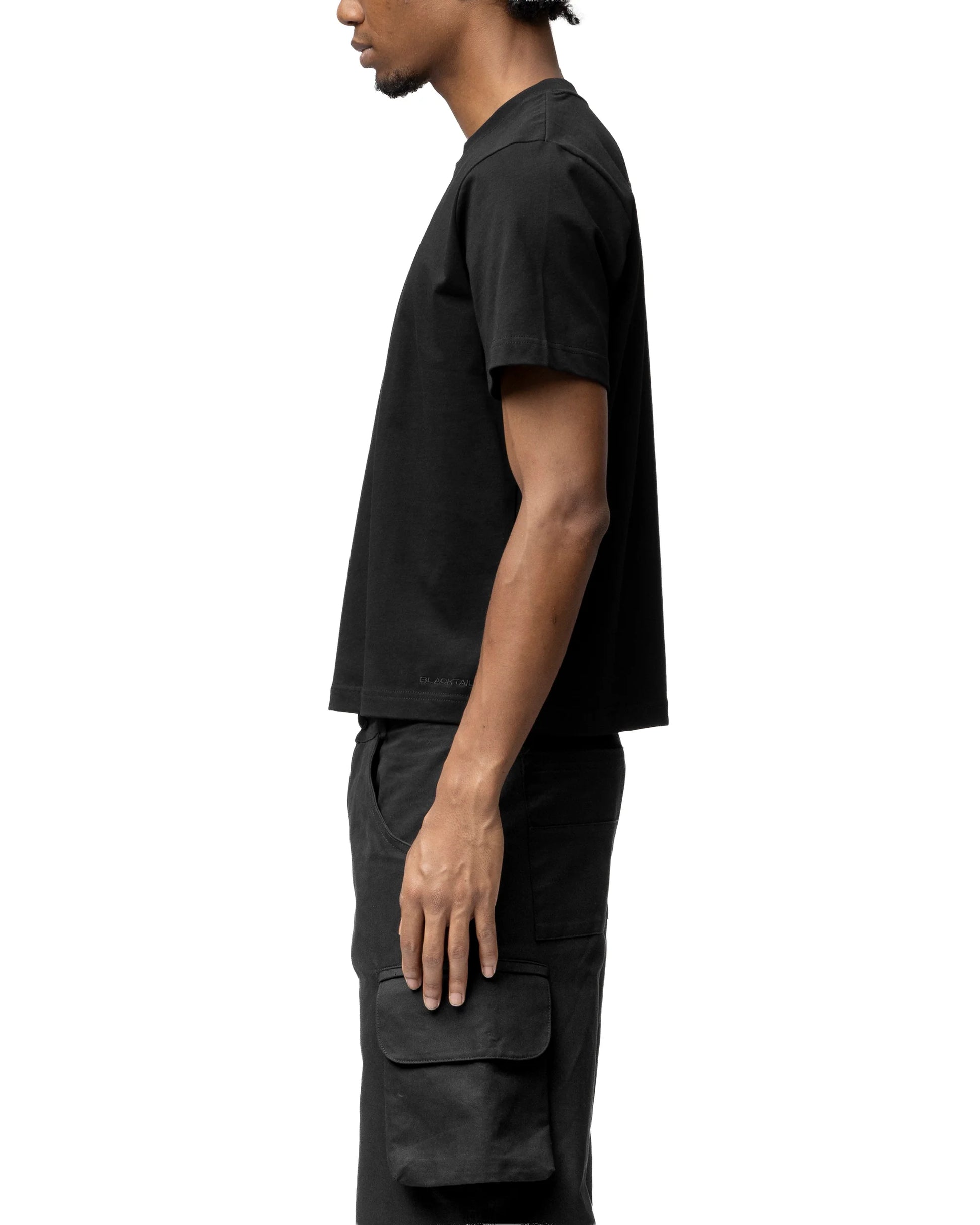 Person wearing a black t-shirt and pants on a white background