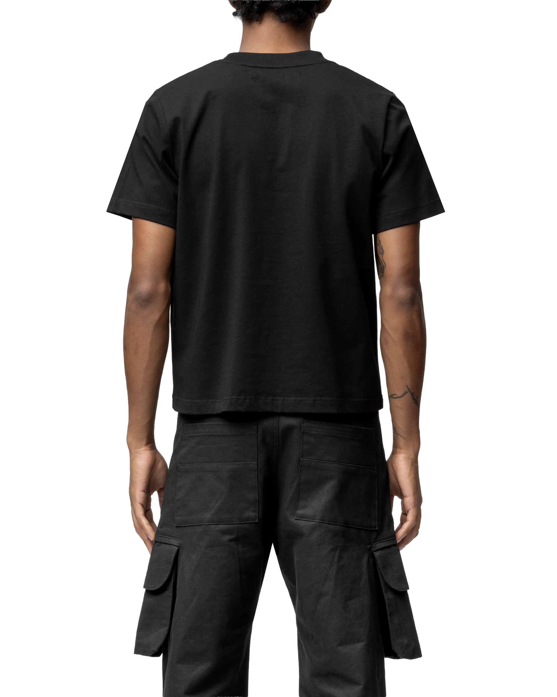 Person wearing a black t-shirt and cargo pants on a white background