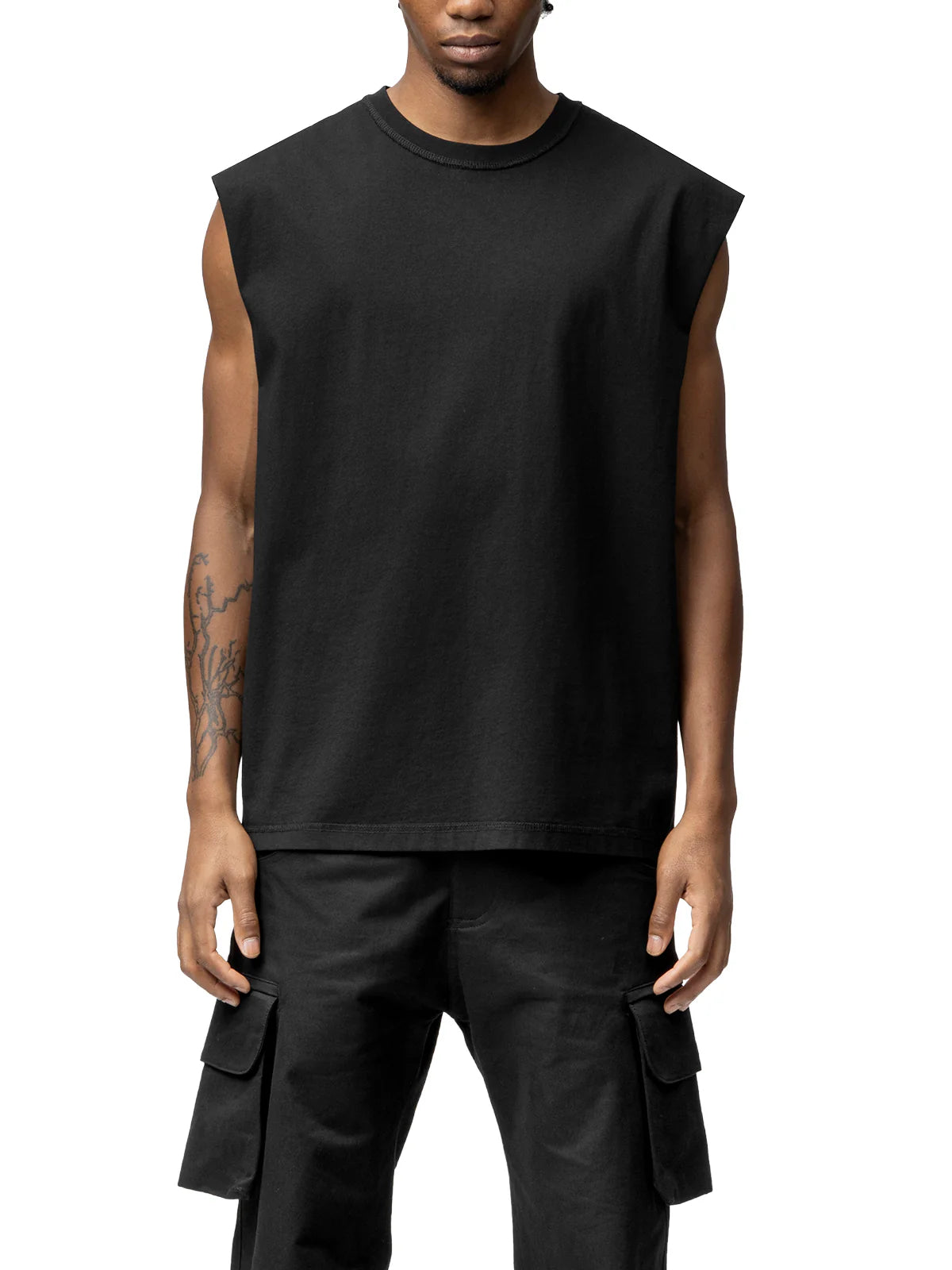 Person wearing a black sleeveless shirt and cargo pants on a white background