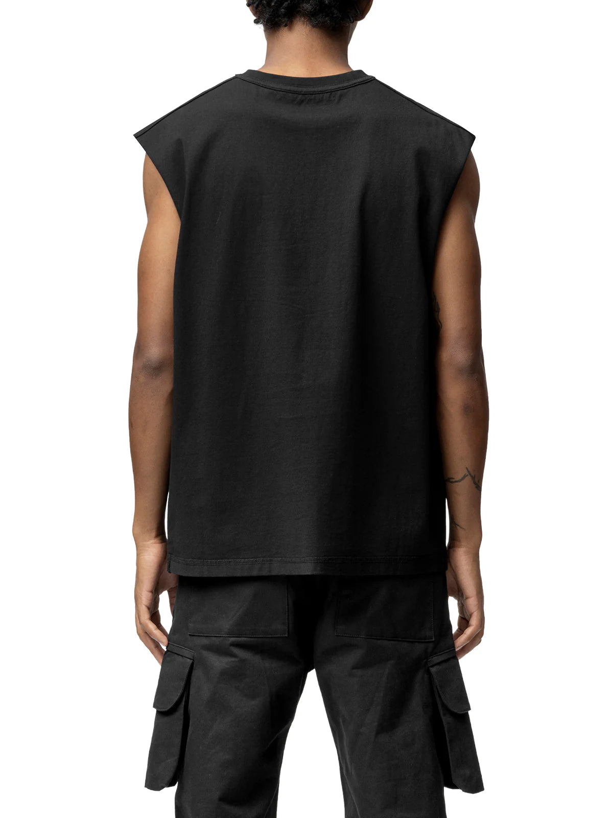 Person wearing a black sleeveless top and cargo pants on a white background