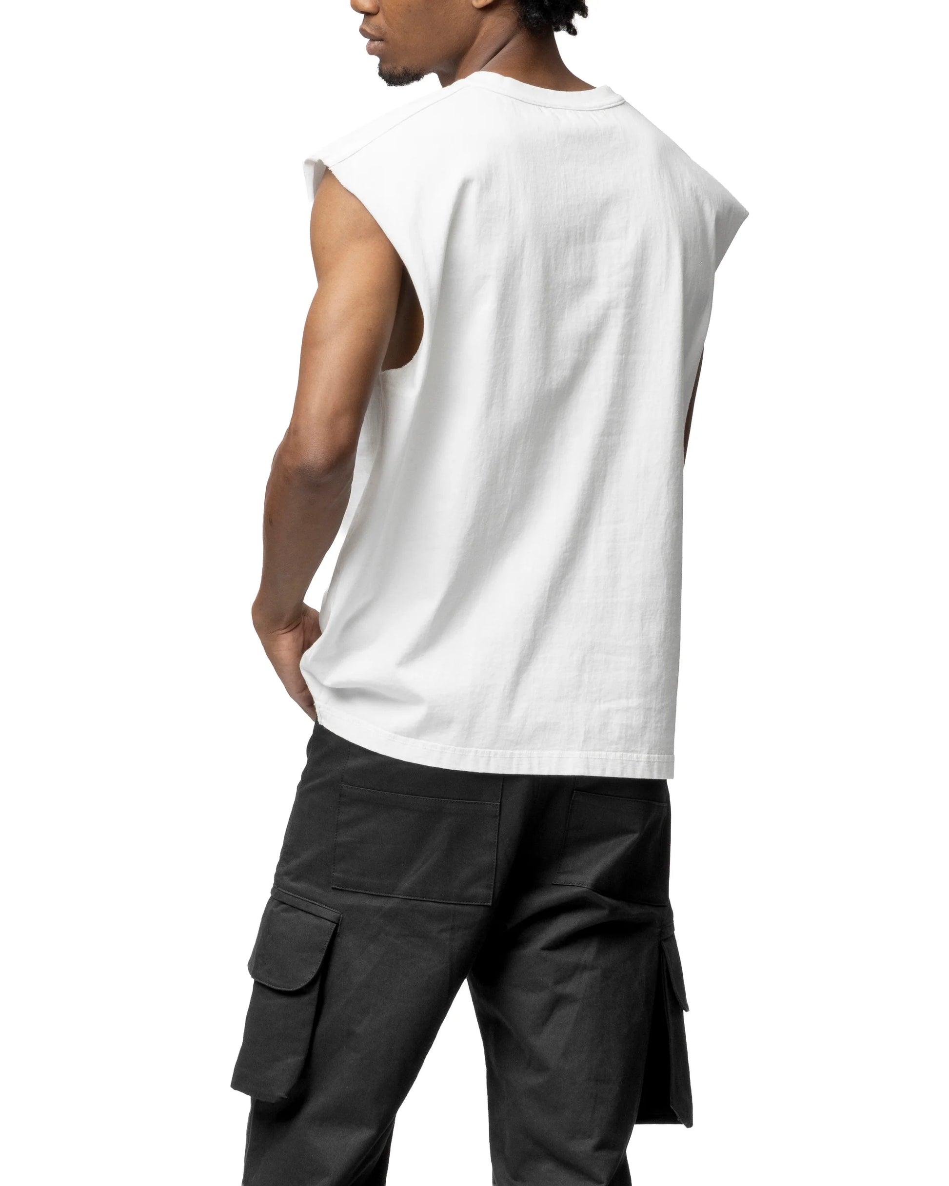 Person wearing a white sleeveless shirt and black cargo pants on a white background