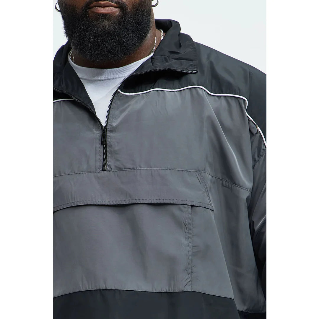 Person wearing a gray and black jacket with a white background