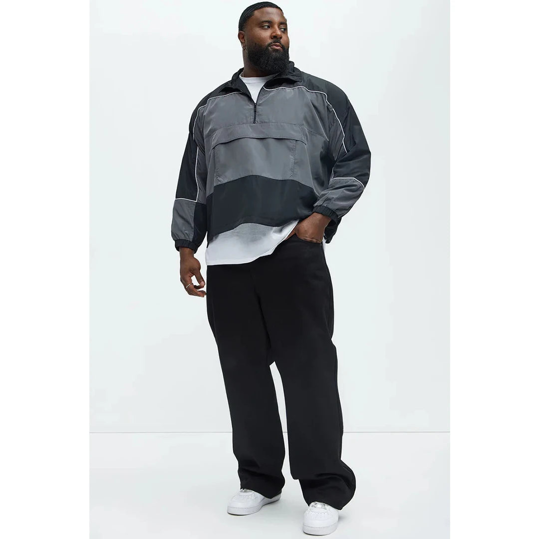 Person wearing a gray and black jacket with a white background