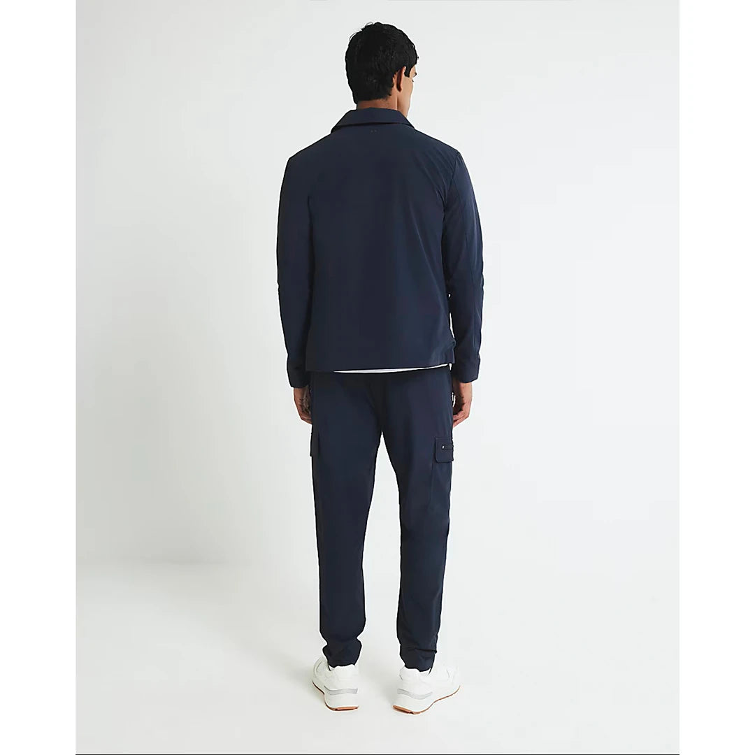 Man wearing a navy tracksuit on a white background