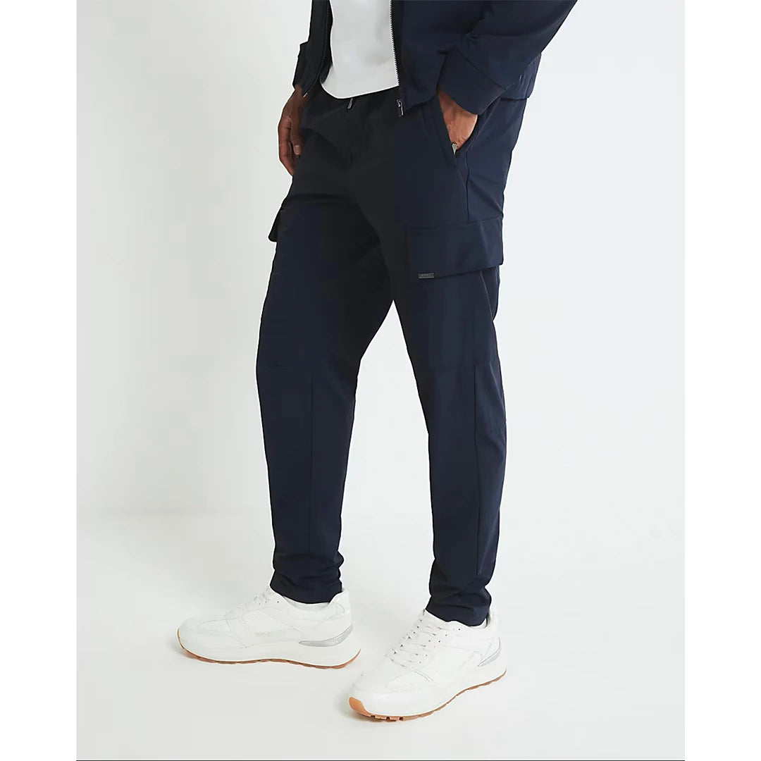Person wearing navy pants and white sneakers on a white background