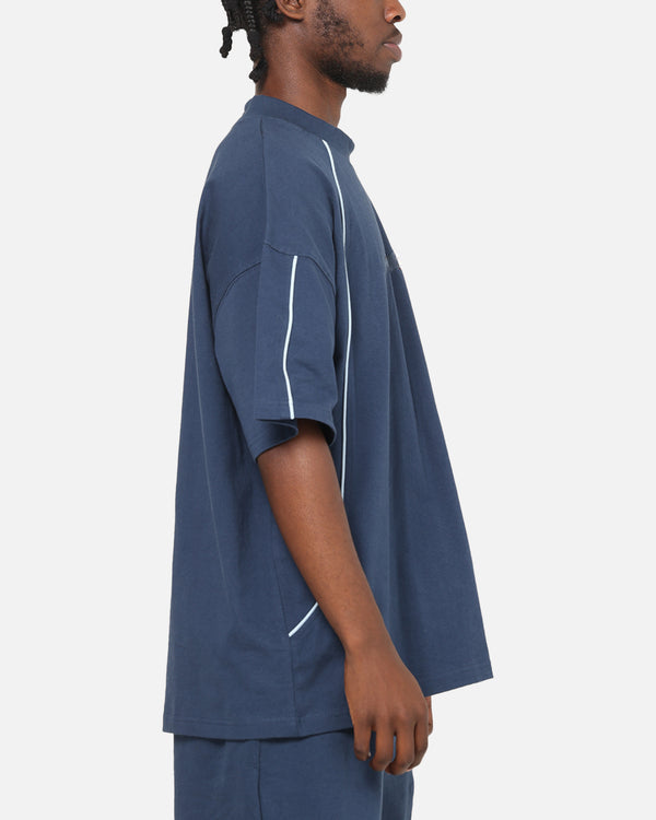 Man wearing a blue t-shirt with white accents on a white background