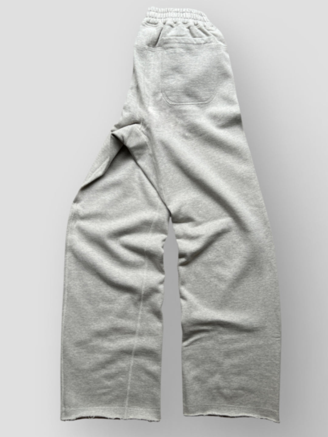  Grey Sweatpant include a buttoned front fly, functional front and back pockets, and subtle construction details that add structure without compromising comfort. 