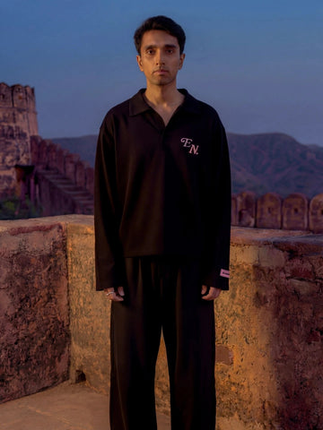 Person wearing a black Polo Oversized Full Sleeve T-shirt with a logo 