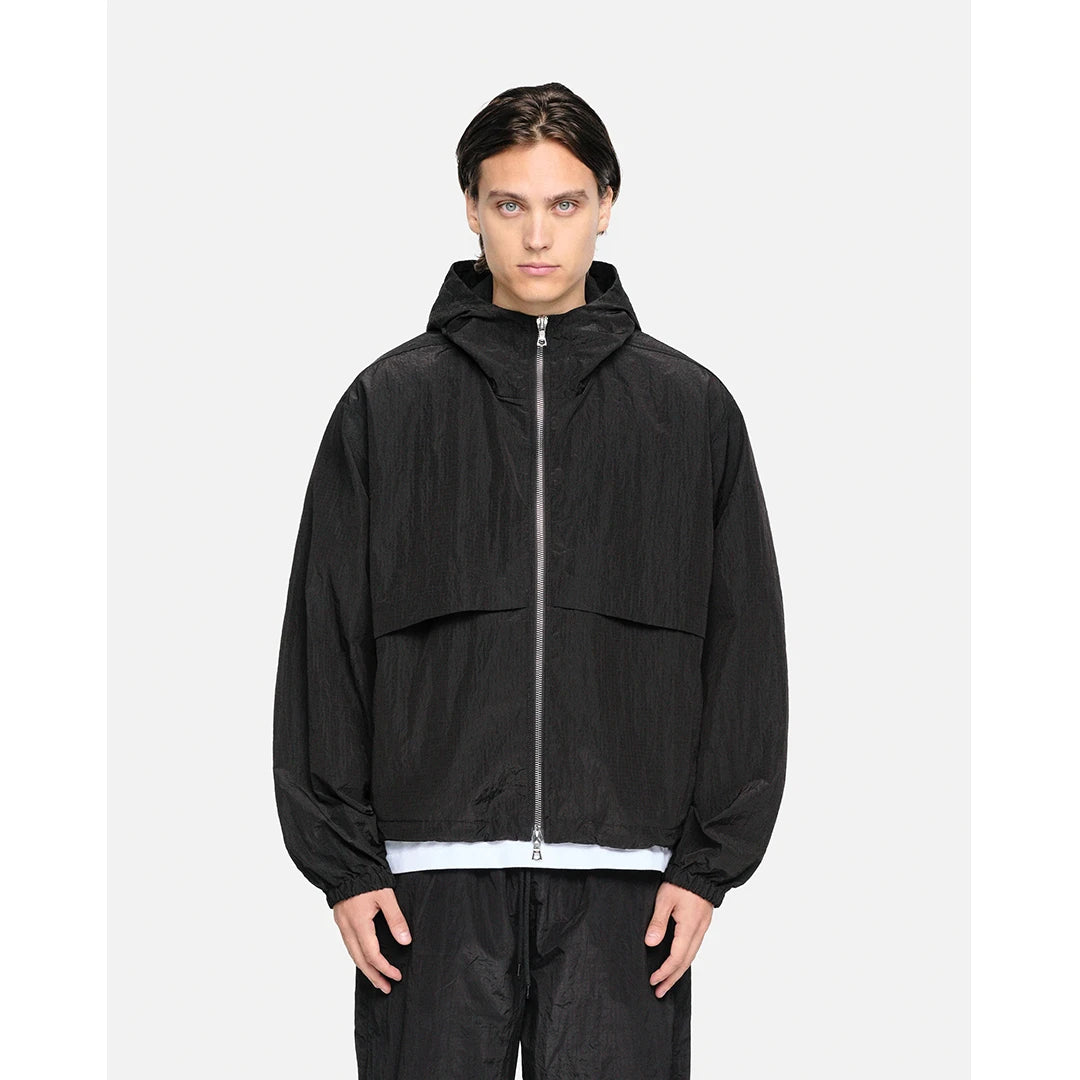 Person wearing a black hooded jacket on a white background