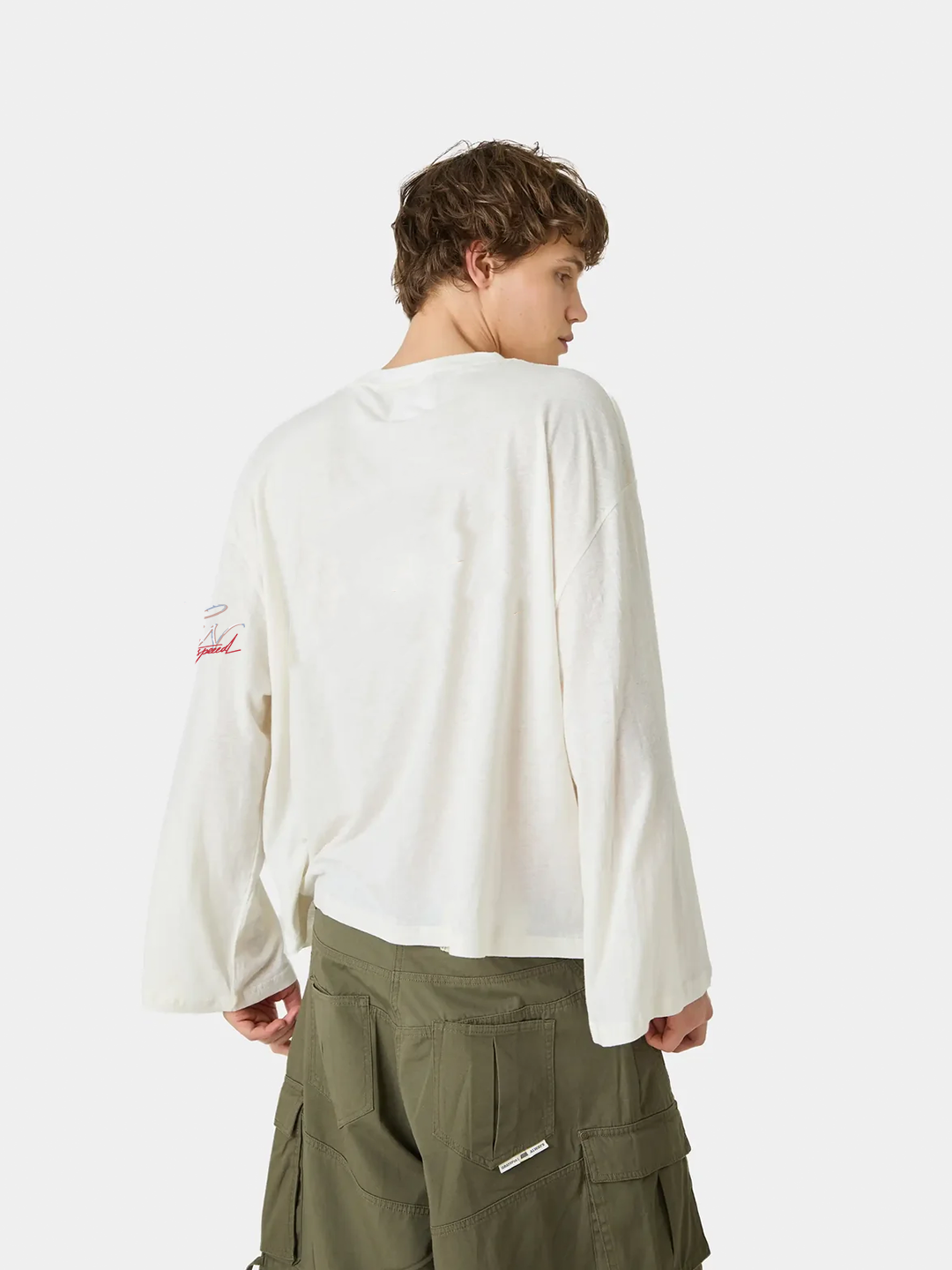 Person wearing a white long-sleeve shirt and green cargo pants on a white background