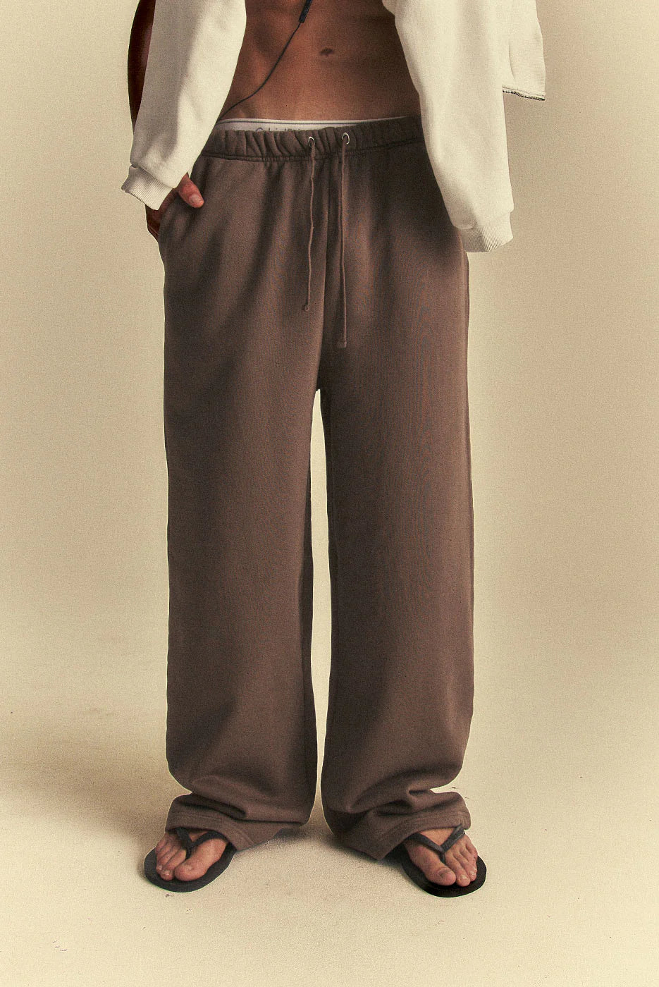 Brown pants worn by a person on a beige background