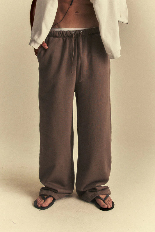 Brown pants worn by a person on a beige background