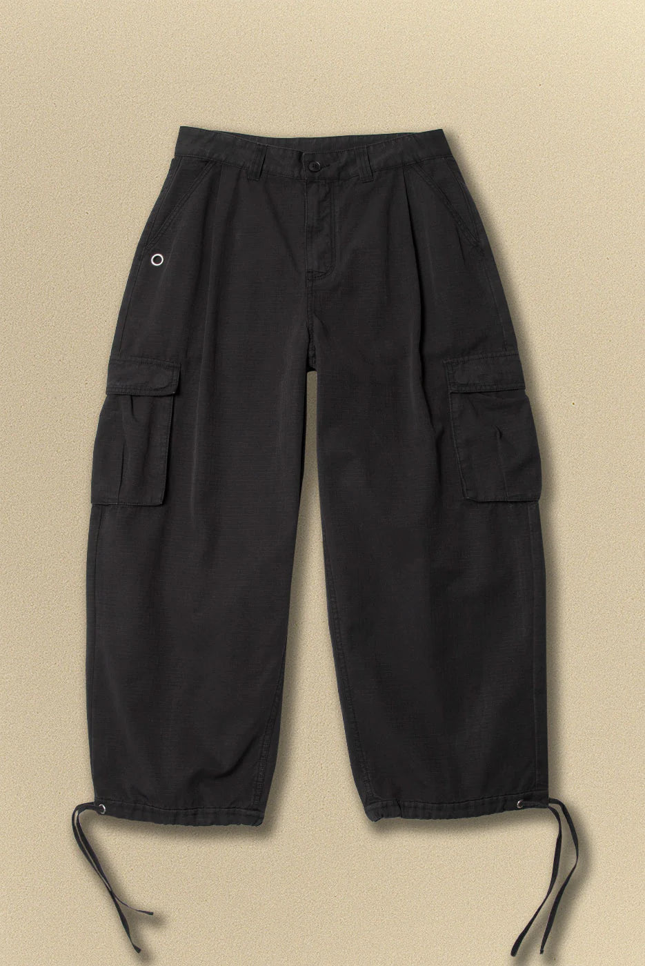 Black cargo pants on a beige background