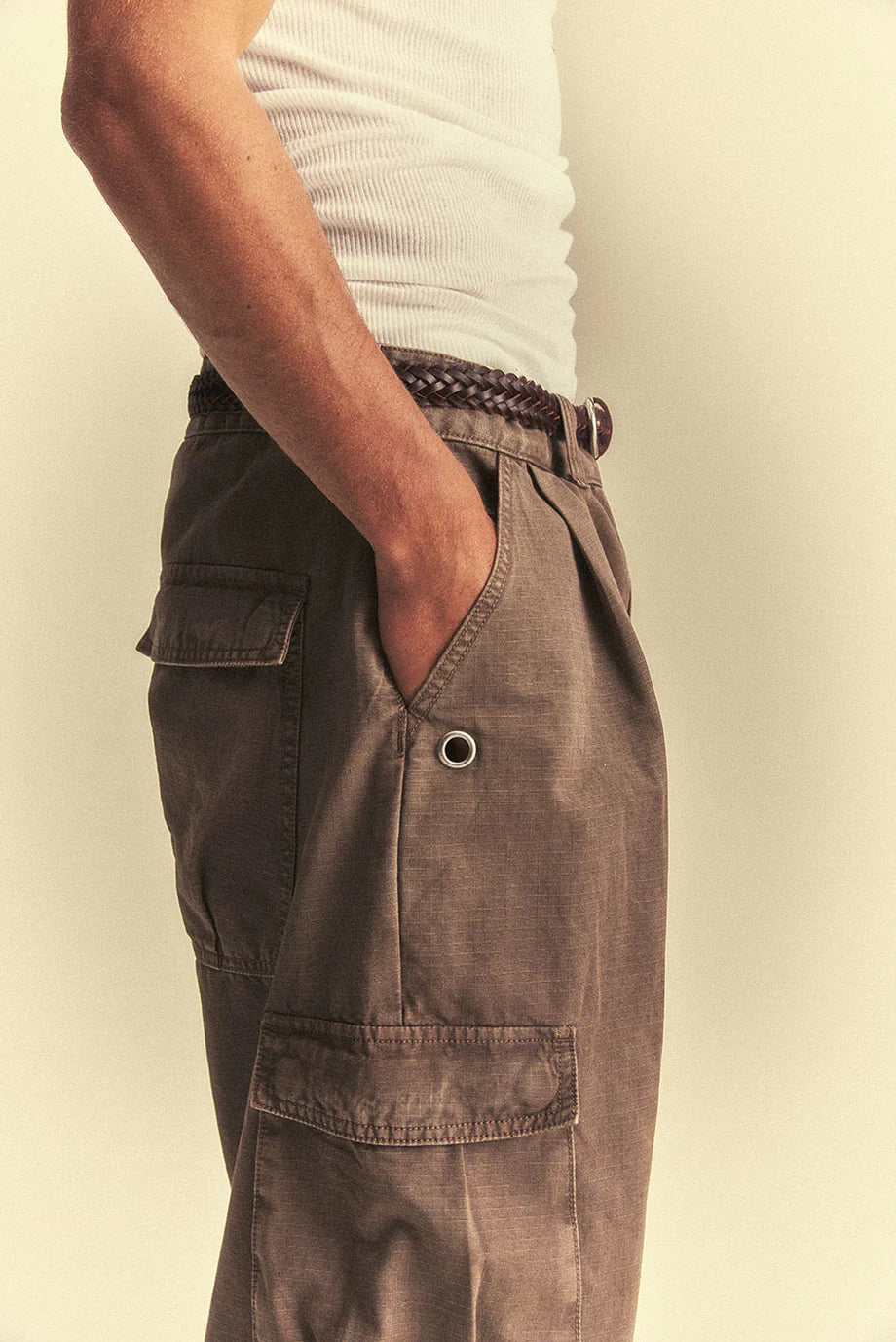 Brown cargo pants worn by a person on a plain background