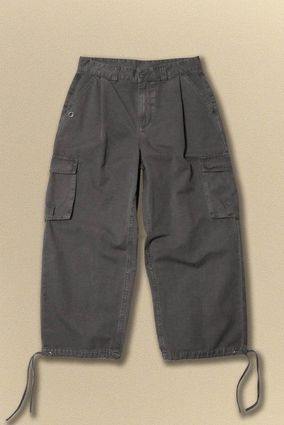Dark grey cargo pants with belt on a beige background