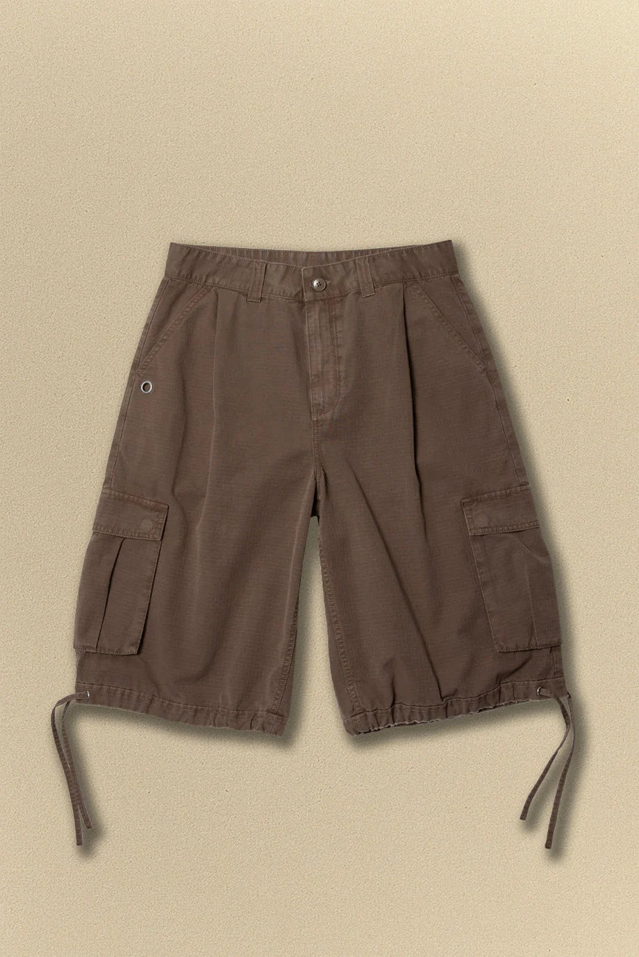 Brown cargo shorts with multiple pockets on a beige background