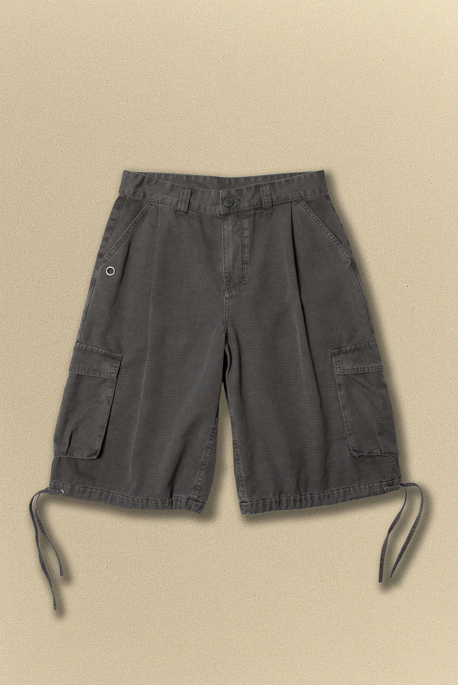 Dark grey cargo shorts with a belt on a beige background