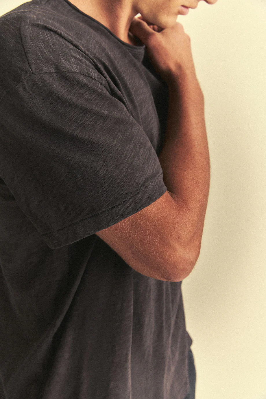 Man wearing a dark grey t-shirt against a plain background