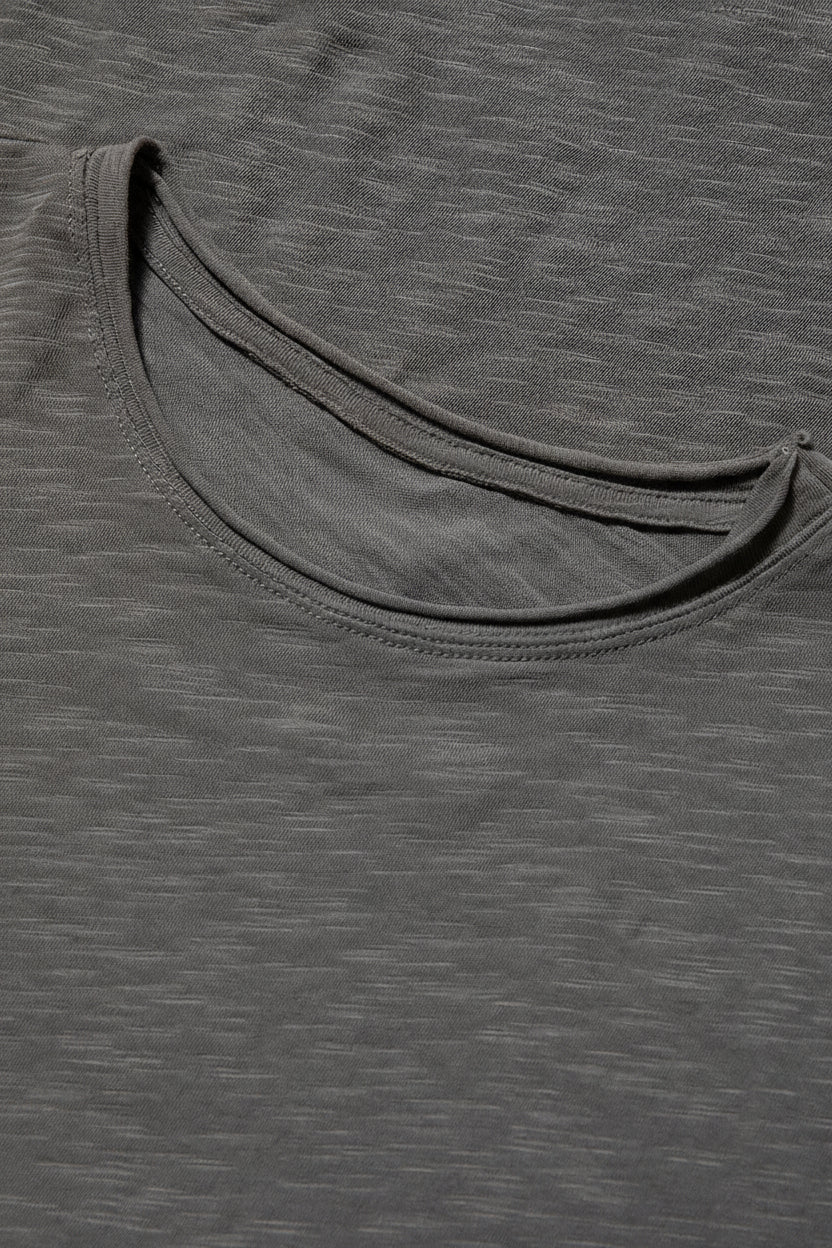 Close-up of a grey t-shirt with a brand label on the collar.