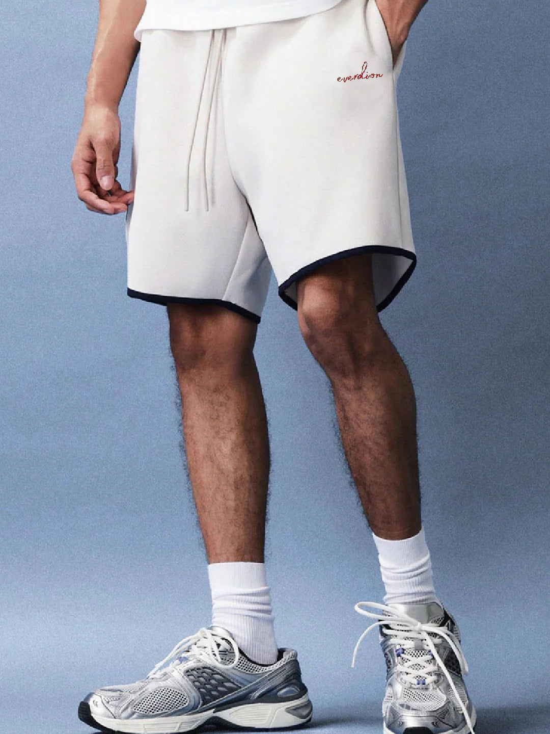Person wearing white shorts with a brand logo 