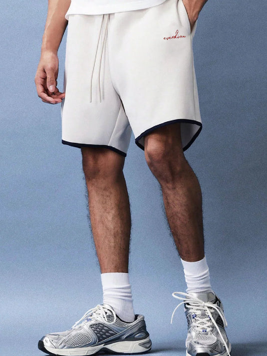 Person wearing white shorts with a brand logo 